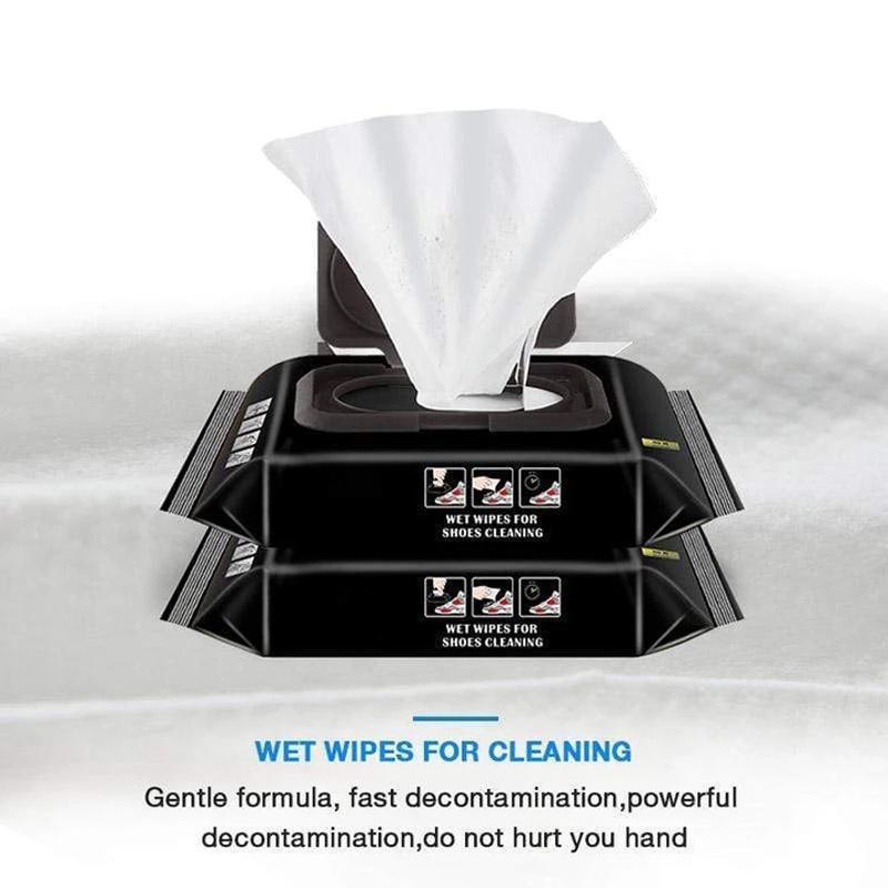 Close-up of an instant shoe shine wipe being used on a black leather shoe, demonstrating quick polish