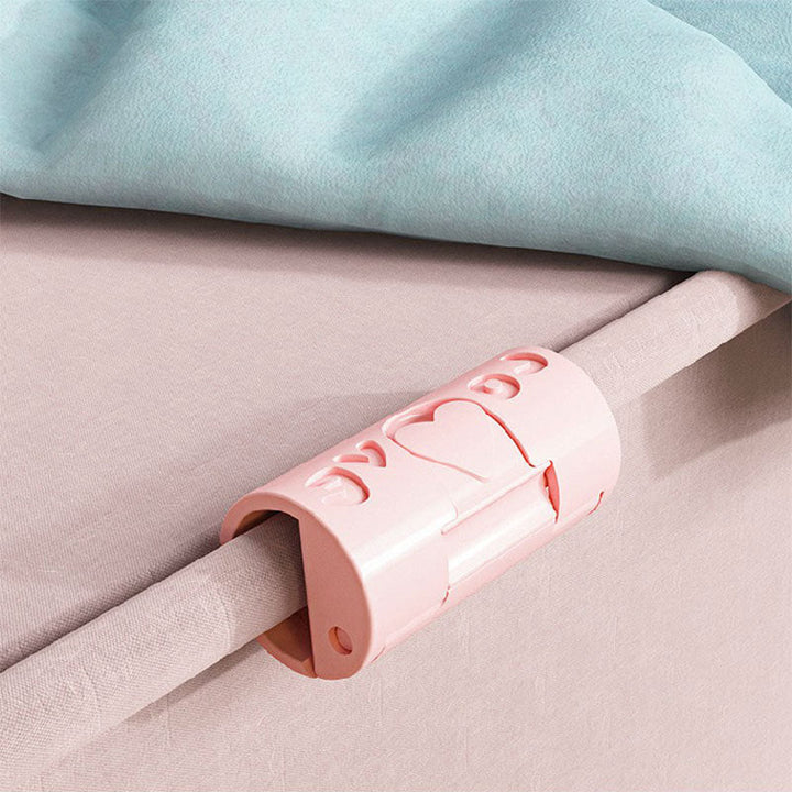 A hand demonstrating installation of a bed sheet fastener on a mattress corner