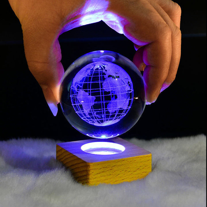 Close-up of a crystal galaxy sphere night light showcasing the intricate laser-engraved planets and stars