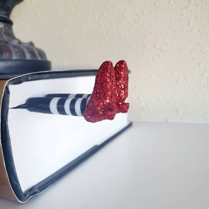 Wicked witch leg bookmark, shown peeking out from an open book, a playful twist for reading