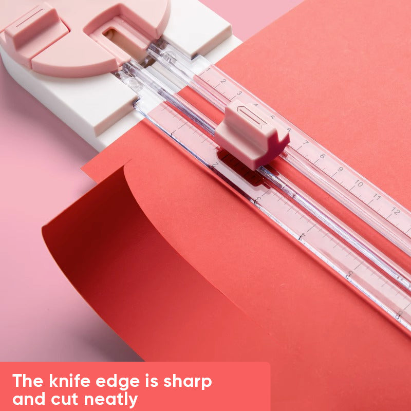Paper cutter in use, demonstrating straight cut on colorful scrapbook paper sheet