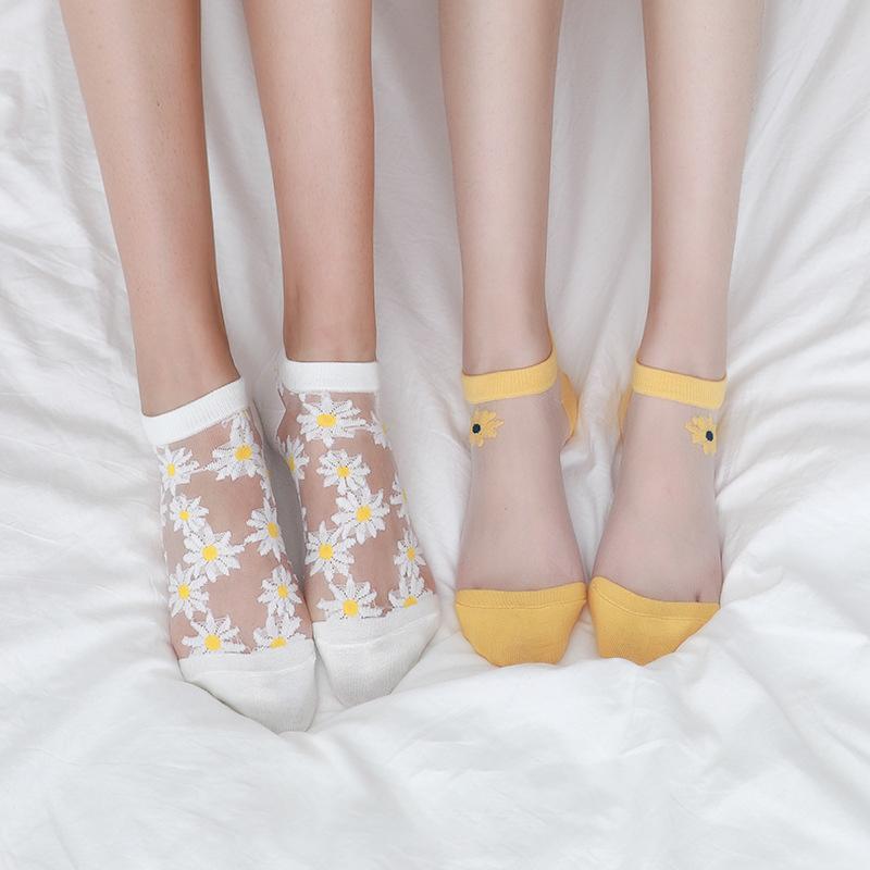 Close-up of a white women's ankle sock with yellow and white daisy floral pattern
