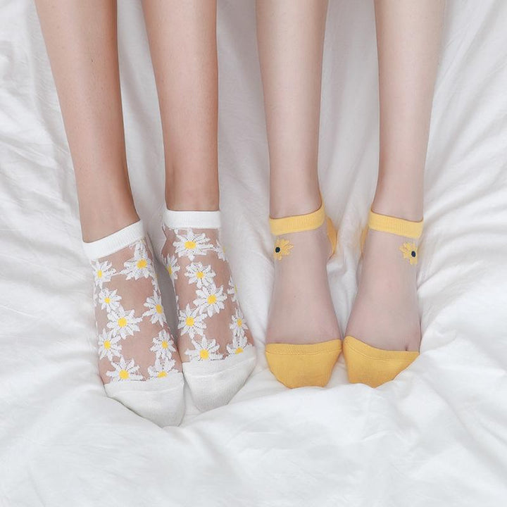 Close-up of a white women's ankle sock with yellow and white daisy floral pattern