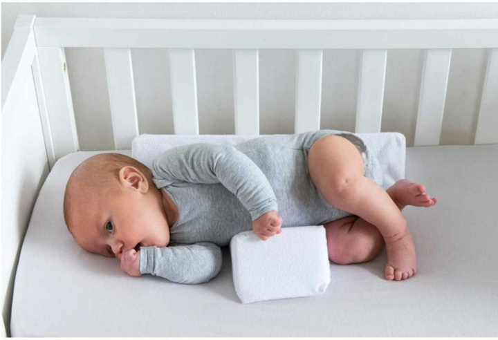 Anti-Roll Adjustable Memory Foam Baby Pillow in Pink, side-sleeper support, gentle and breathable design for newborns.