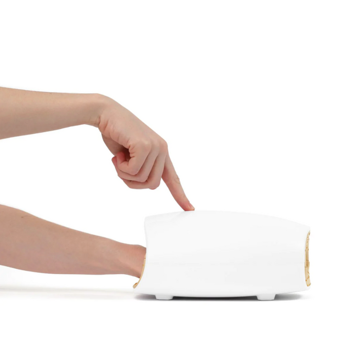 Cordless USB hand massager with white durable exterior, soft cushioning, offering heat and compression for hand relaxation.