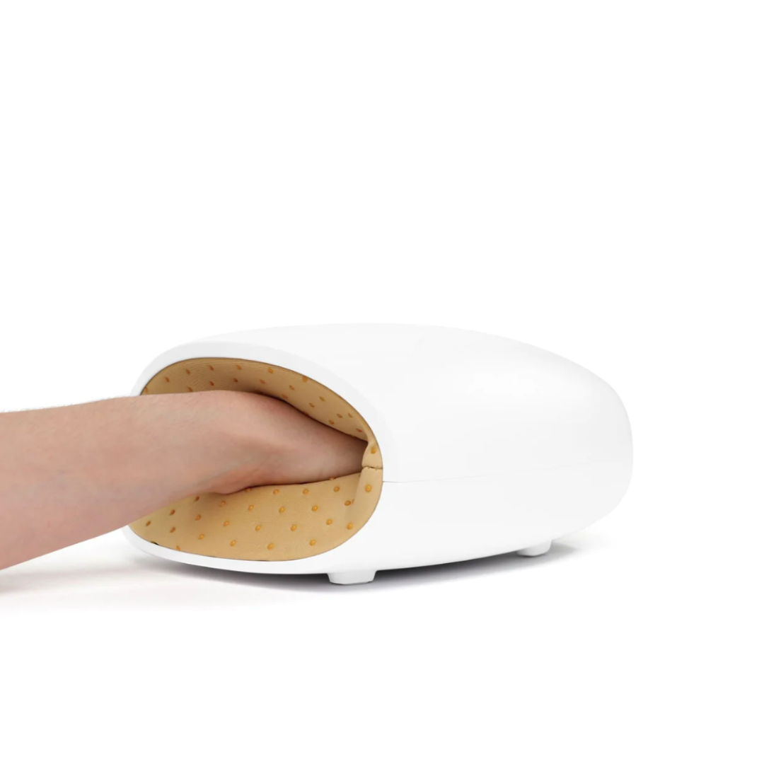 Cordless USB hand massager with white durable exterior, soft cushioning, offering heat and compression for hand relaxation.