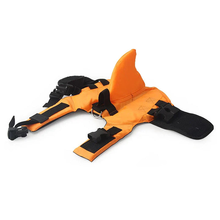 Dog life jacket with shark fin, offering buoyancy and fun for all water activities; bright material, adjustable straps.