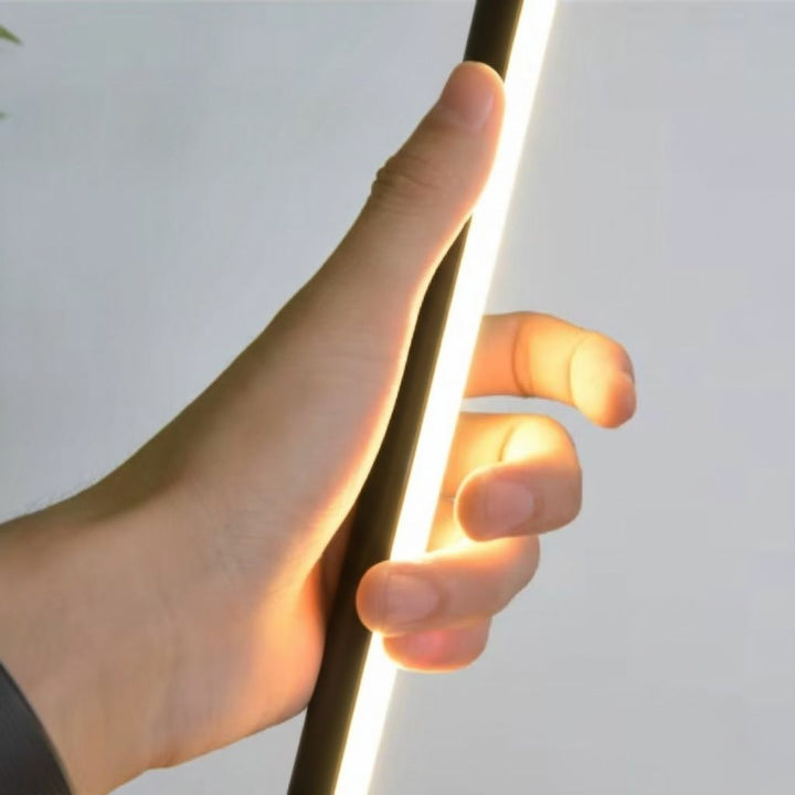 Elegant LED floor lamp with adjustable soft glow, minimalist design in aluminum and acrylic, ideal for modern living rooms.