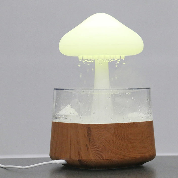 "Elegant white humidifier with wooden finish, emits soothing mist and rain sounds for relaxation and improved sleep."