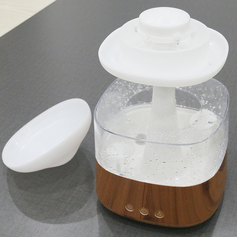"Elegant white humidifier with wooden finish, emits soothing mist and rain sounds for relaxation and improved sleep."