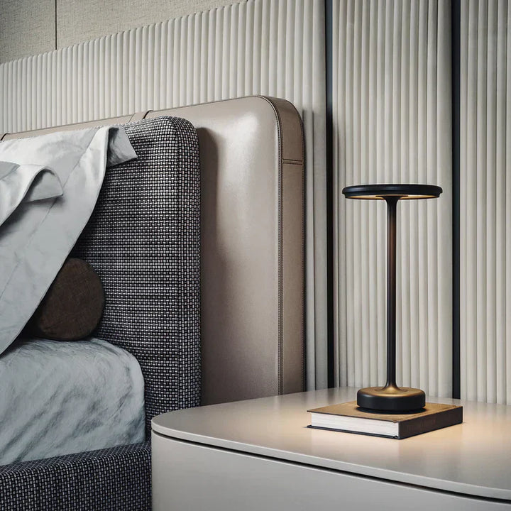"Elegant wireless table lamp with sleek curves, gold finish; perfect for versatile ambient lighting on any table or desk."