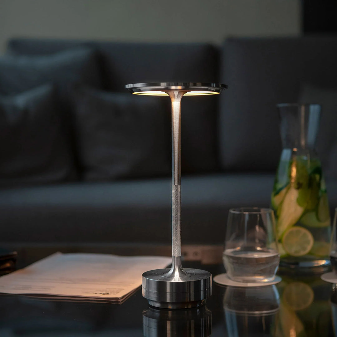 "Elegant wireless table lamp with sleek curves, gold finish; perfect for versatile ambient lighting on any table or desk."