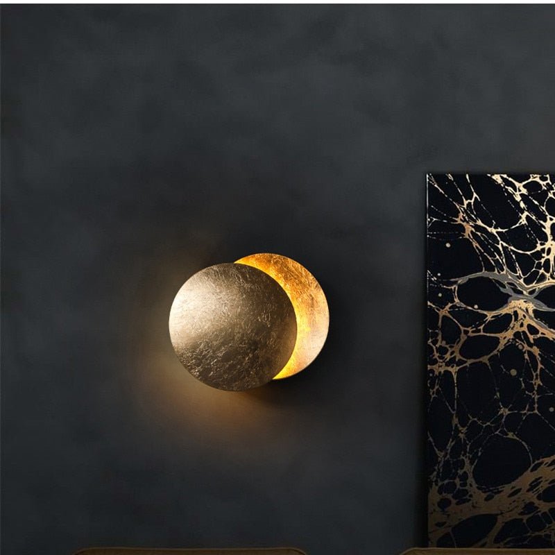 "Golden Solaris Wall Lamp with eclipse-inspired design, featuring elegant gold discs and warm LED glow for home decor."