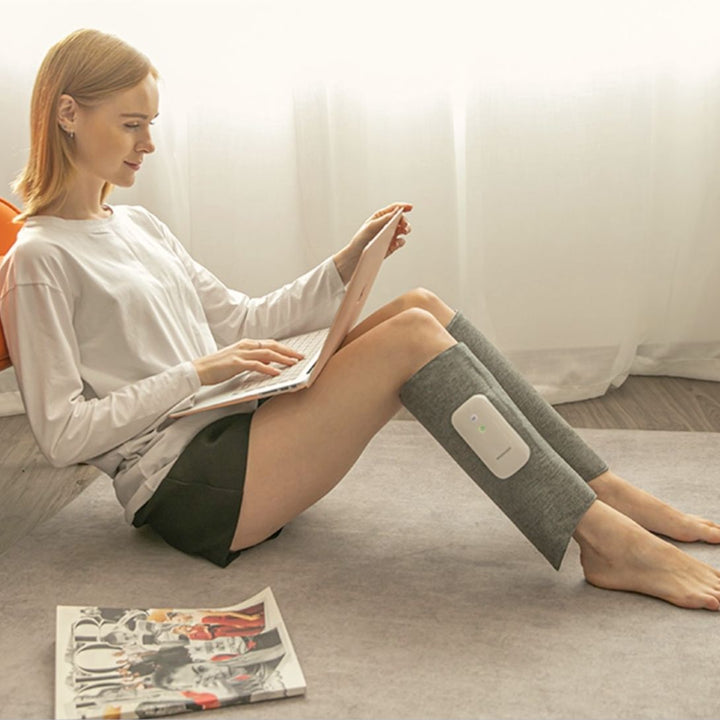 "Heated leg massager wraps around calves and ankles, shown in use. Provides soothing heat and customizable massage for relaxa