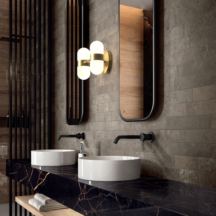 Modern brass wall lamp featuring snow-white alabaster shades with brown veining; elegant indoor lighting fixture.