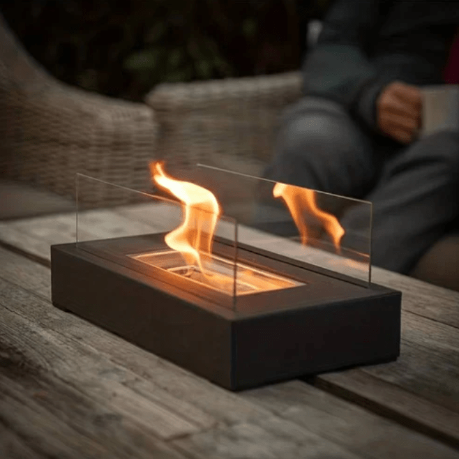 "Modern portable rectangular tabletop fire pit with real flame, sleek black design, tempered glass, and stainless steel body.