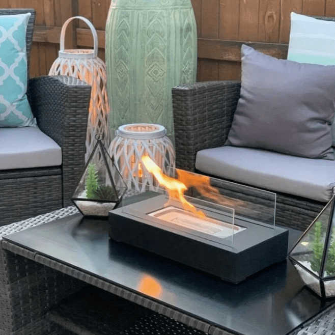 "Modern portable rectangular tabletop fire pit with real flame, sleek black design, tempered glass, and stainless steel body.