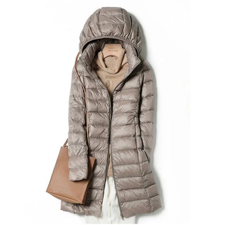 "Stylish women's long hooded puffer jacket with quilted design and extended length for warmth and protection in winter."