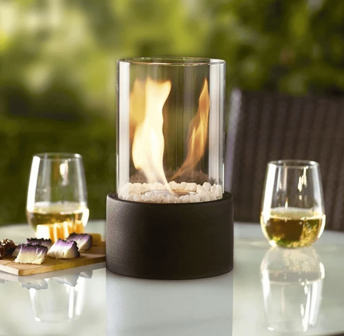 "Tabletop Portable Fire Pit with marble base, glass cylinder, sleek modern design, ideal for indoor and outdoor ambiance."
