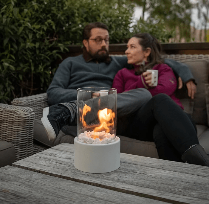 "Tabletop Portable Fire Pit with marble base, glass cylinder, sleek modern design, ideal for indoor and outdoor ambiance."