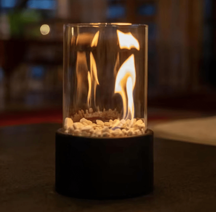 "Tabletop Portable Fire Pit with marble base, glass cylinder, sleek modern design, ideal for indoor and outdoor ambiance."