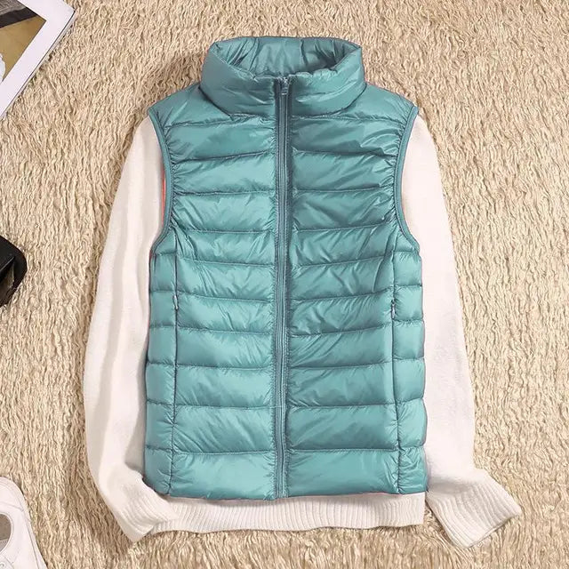 "Ultra-light women's autumn down vest in sleek fit, available in Black, Blue, Khaki; stylish and packable for cool days."