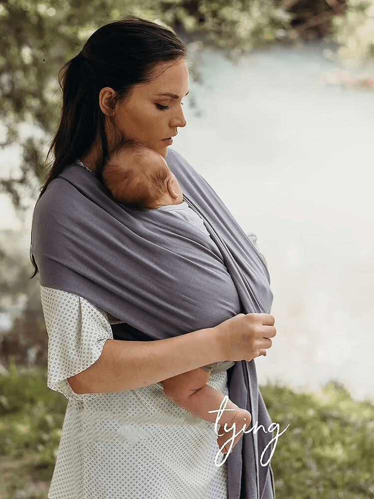 "Unisex ergonomic baby wrap carrier, grey, enveloping baby and parent comfortably for hands-free convenience."