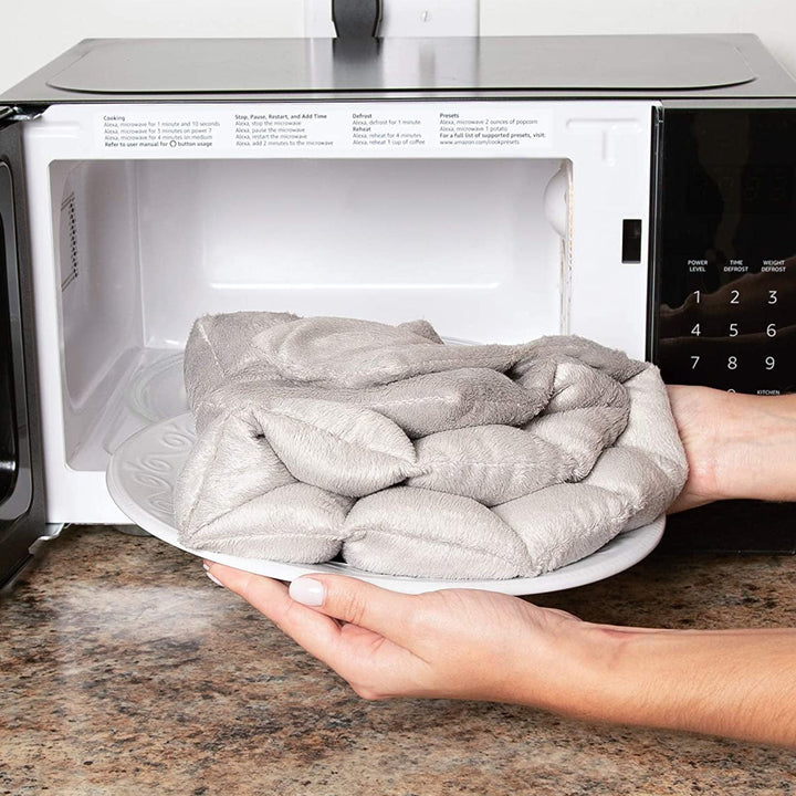 "Weighted Neck & Shoulder Wrap in beige, showing ergonomic design with even distribution for stress relief and relaxation."