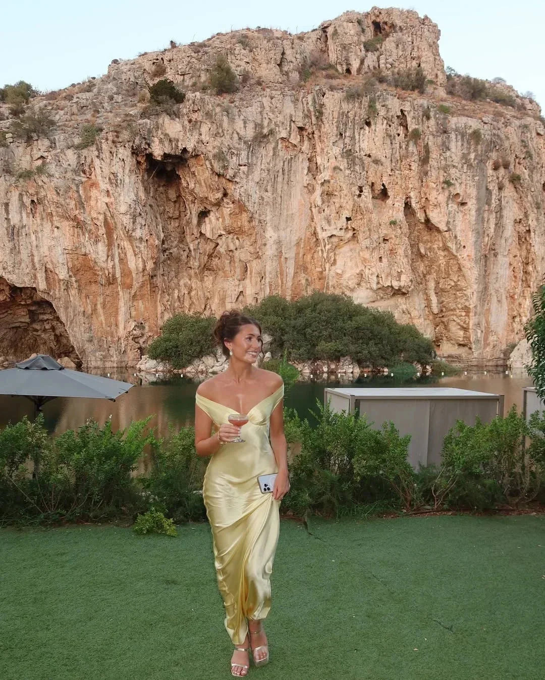 Women's off-shoulder yellow maxi dress with matching clutch; chic design, flowing silhouette, perfect for elegant events.