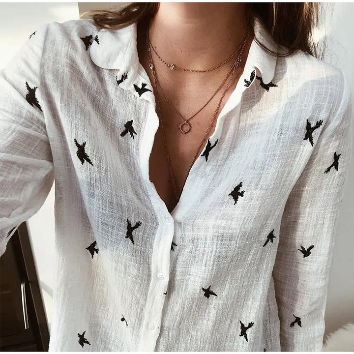 "Women's relaxed bird-print button-up blouse with colorful bird patterns, flowy silhouette, perfect for casual or office wear