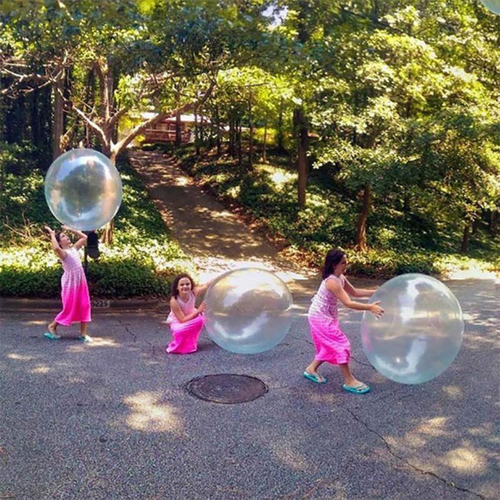 A child attempting to 'ride' the giant inflatable bubble ball, showcasing its flexibility.