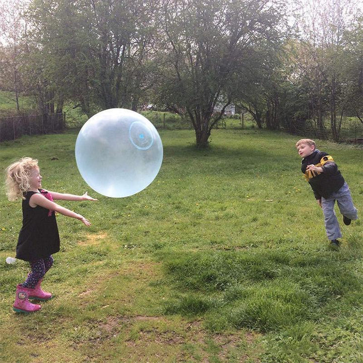 Several giant inflatable bubble balls in various stages of inflation, ready for outdoor toy sales.