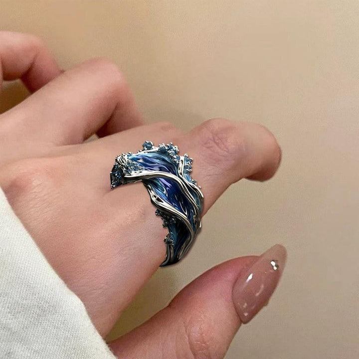 Silver ocean wave ring, adjustable and unisex, featuring a smooth, polished finish and blue resin
