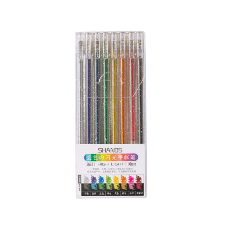Hand holding a glitter gel pen over a detailed adult coloring book page, adding sparkle
