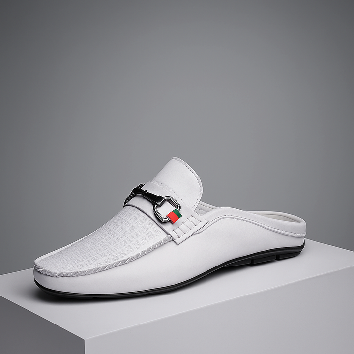 Black leather slip-on mules for women with elegant metal bit detail, perfect for casual or dressy wear.