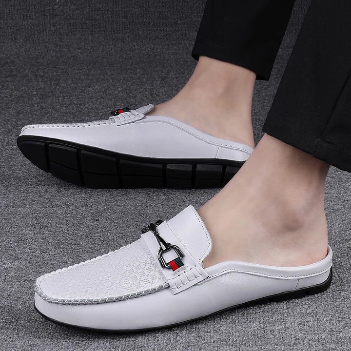 Detailed view of women's white leather slip-on mules, highlighting the perforated texture and metal bit.