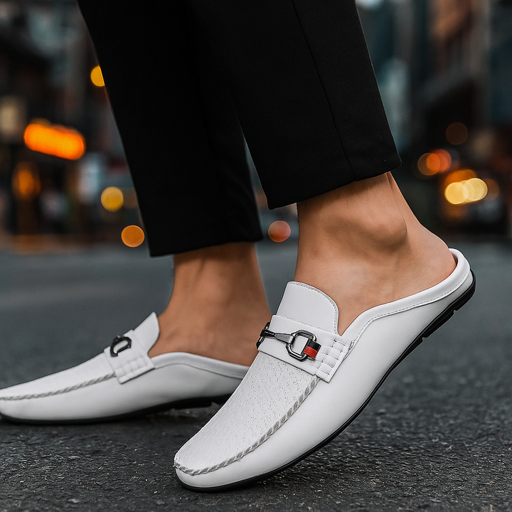 Women's black leather slip-on mules featuring a sophisticated metal bit, ideal for office or evening.