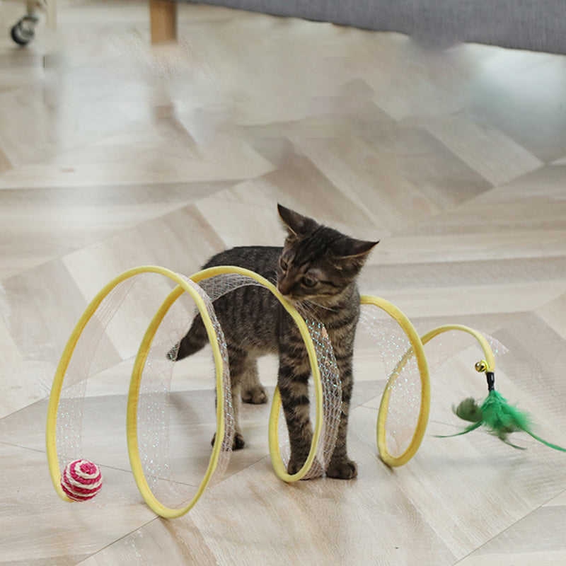Happy cat peeking out of a collapsible tunnel opening, engaged with a dangling feather toy.