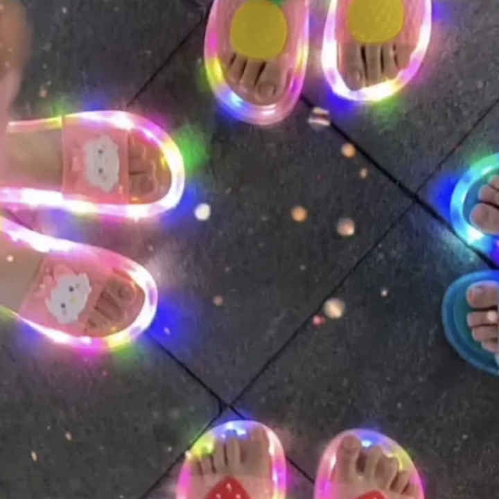 Front view of red LED light-up kids slippers, durable PVC shoes for summer activities.