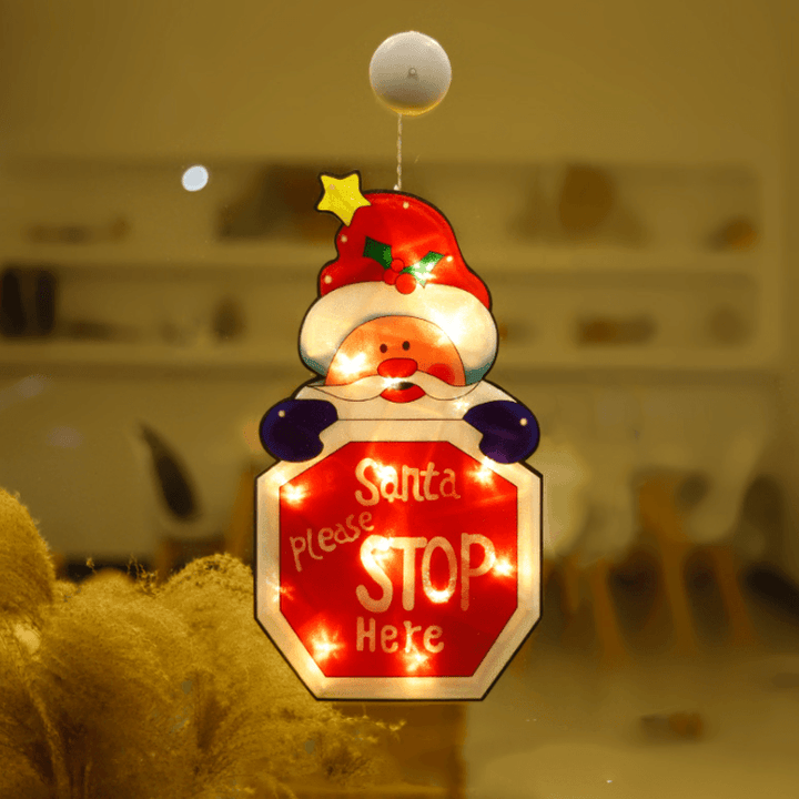 Holiday window decor with lit-up Christmas tree LED light, secured by suction cup, creating a festive ambiance