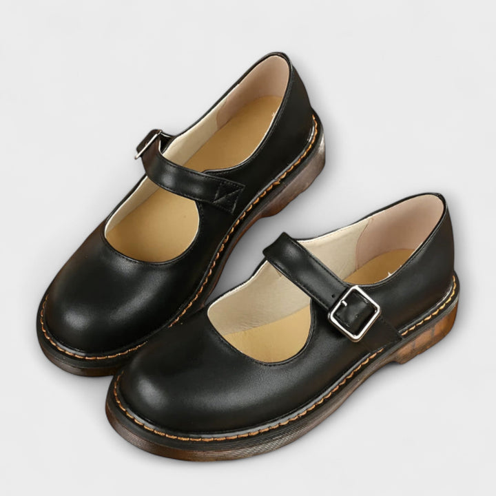 Stylish black Women's Mary Jane shoes, featuring a timeless buckle strap & rounded toe for casual or work fashion.