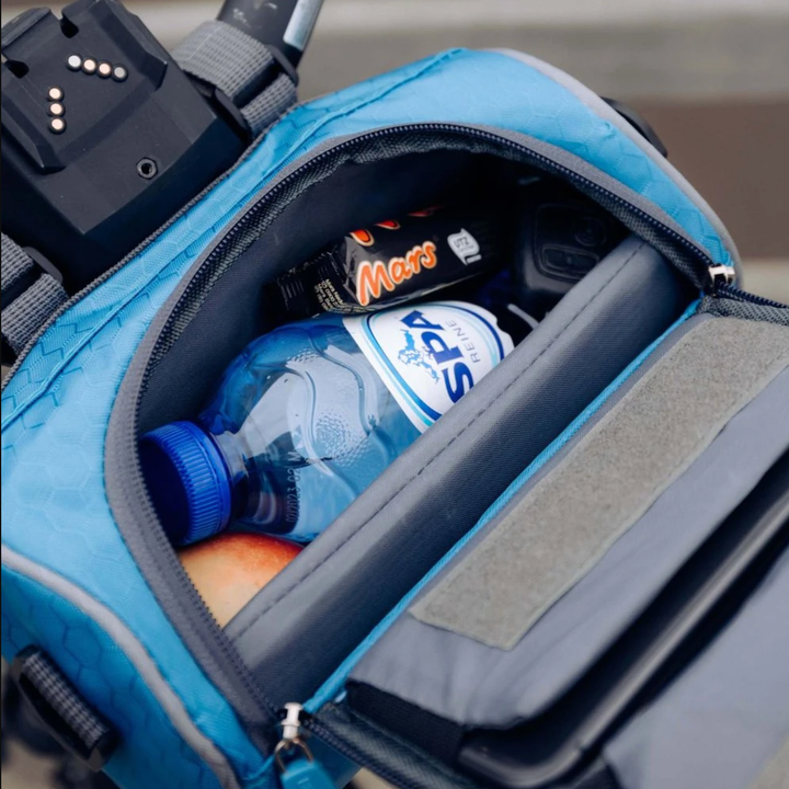 Cyclist using a handlebar bag with phone pocket, accessing map during an outdoor ride.