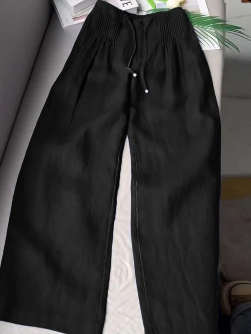 Detail of the wide-leg hem on women's flowy trousers, highlighting the fabric drape and movement.