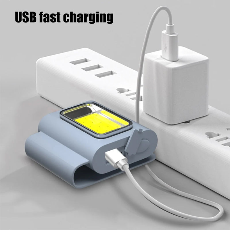 Magnetic work light gripping a car hood, showcasing its utility as an automotive repair tool