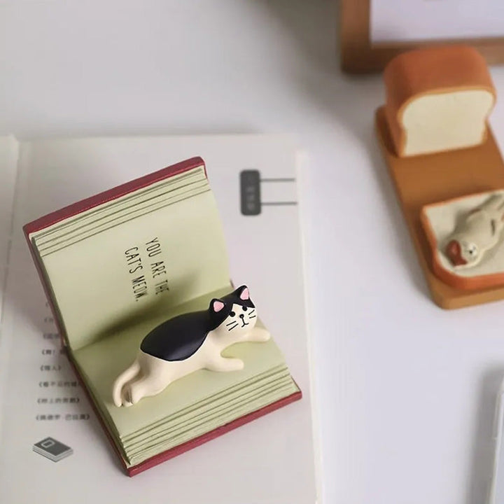 White cat cell phone stand, charming desk decor for cat lovers, holding a smartphone securely
