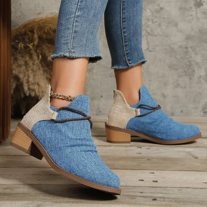 Lace-up front of a women's comfortable, denim blue woven textile boot with block heel