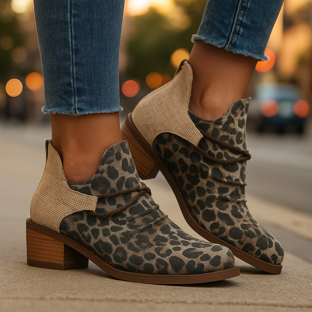 Close-up of women's denim blue woven textile boots, showing block heel and lace detail