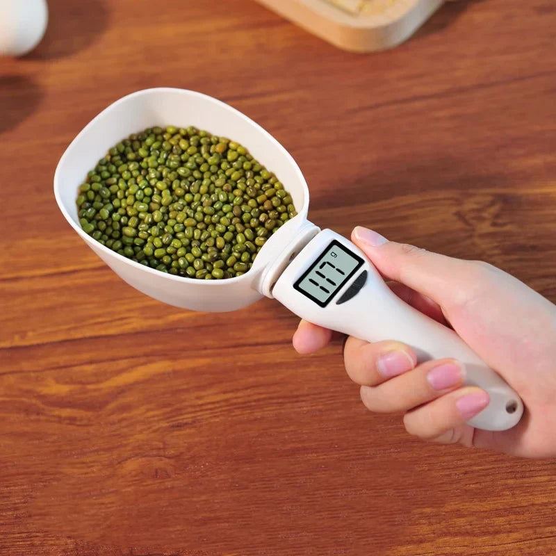 Close-up of pet food measuring scoop scale, showing digital display with ounces and grams