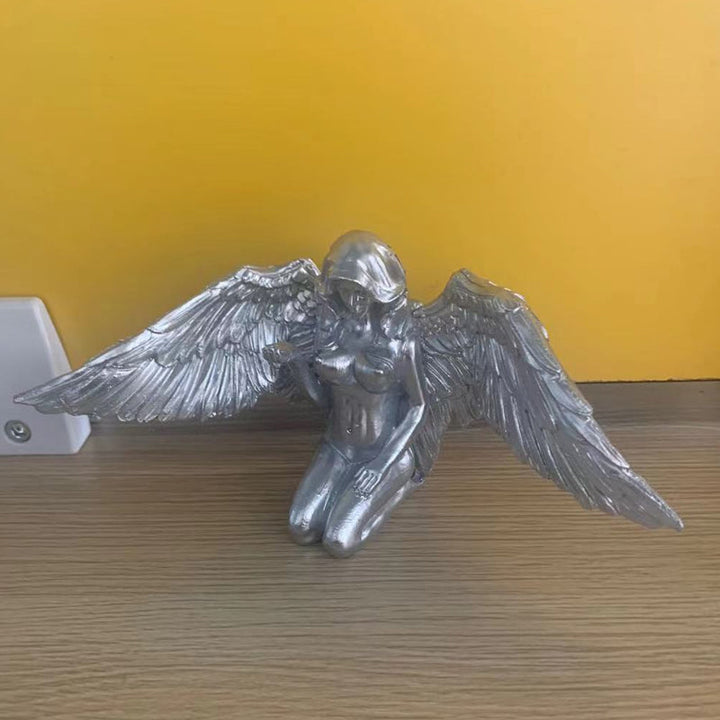 Detailed angel figurine with open wings in a kneeling pose, a fine resin statue