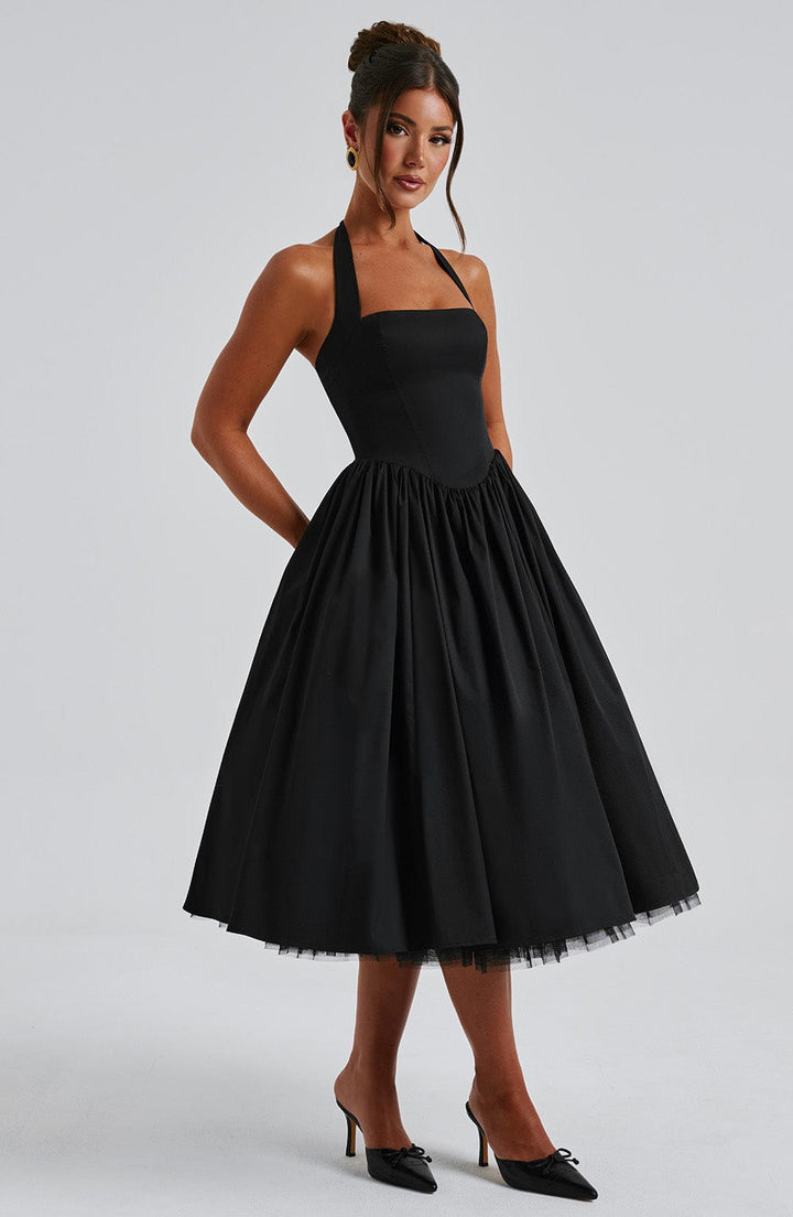 Woman accessorizing the black halter neck midi dress for an elegant and formal occasion look
